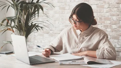 Smiling woman write notes watch webinar study work on laptop, young student  lea 库存影片 196463982