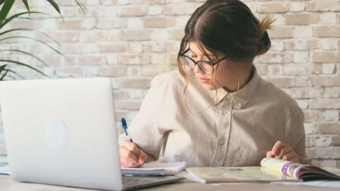 Smiling woman write notes watch webinar study work on laptop, young student  lea 库存影片 196464124