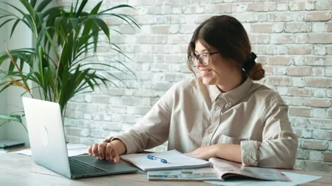 Smiling woman write notes watch webinar study work on laptop, young student  lea Stock Footage 196464171