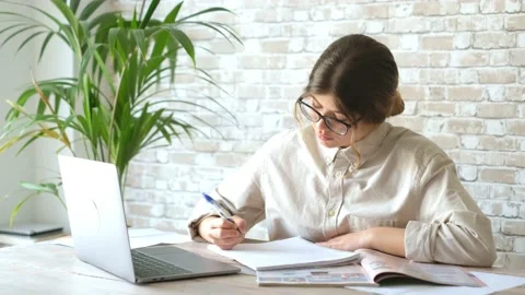 Smiling woman write notes watch webinar study work on laptop, young student  lea 库存影片 196464322