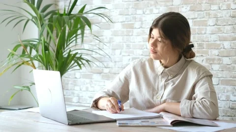 Smiling woman write notes watch webinar study work on laptop, young student  lea 库存影片 196464407