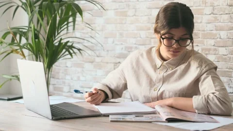 Smiling woman write notes watch webinar study work on laptop, young student  lea 库存影片 196464409