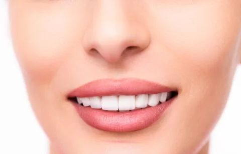 Smiling woman's lips and teeth on white background Stock Photos