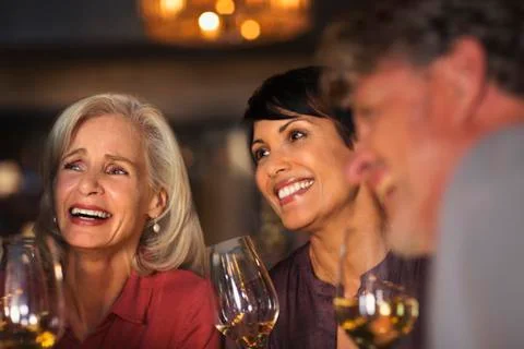 Smiling women drinking white wine at bar Stock Photos