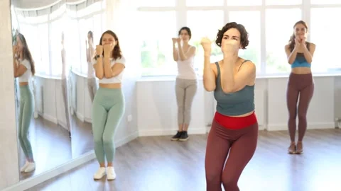 Smiling women learning swing steps at dance class Stock Footage 297509809