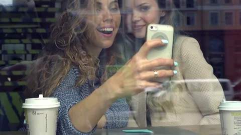 Smiling women talking selfie with smart phone while having lunch in cafe. View Stock Footage 78377151