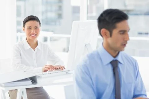 Smiling work team using computer Stock Photos