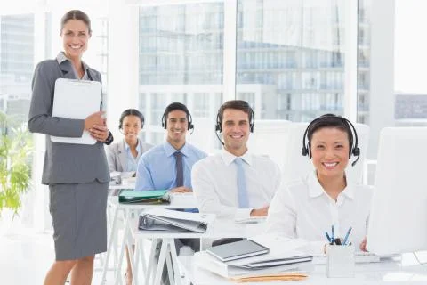 Smiling work team using computer Stock Photos