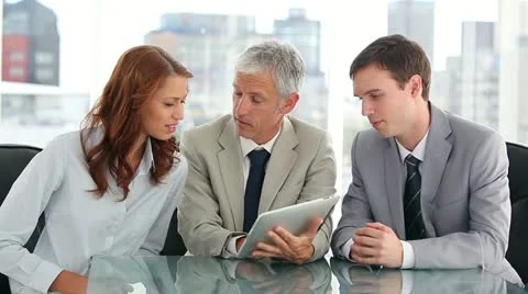 Smiling work team using a tablet computer Stock Footage 10858437