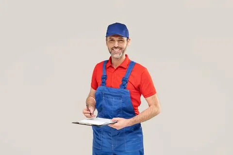 Smiling worker, repairman with documents in hands. Studio shot. Stock-Fotos