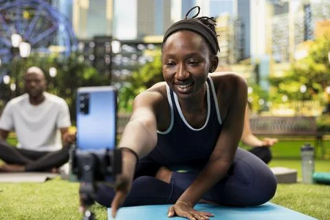 Smiling yoga instructor leaning close to start recording fitness vlog Stock Photos