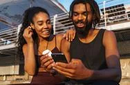 Smiling Young Afro American Couple Using Mobile Phone Stock Photos