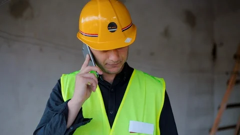Smiling Young Architect and talking on mobile phone while standing Video stock 129447069