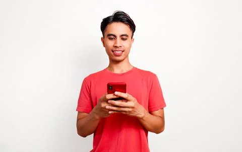 Smiling young Asian man using smartphone and looking at screen with happy e.. Stock Photos