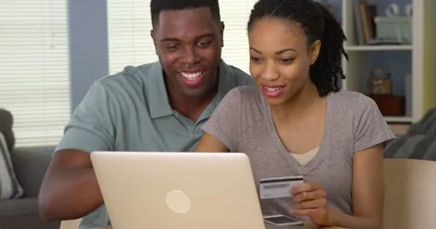 Smiling young black couple using credit card to make online purchases Video stock 42658903