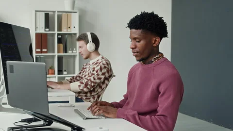 Smiling Young Black IT Developer Typing at Computer Desk in Startup Office Video stock 330129483