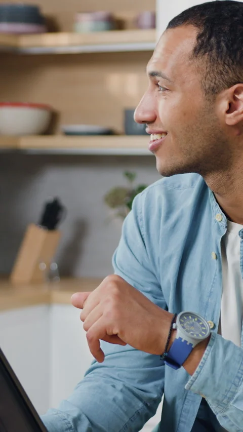 Smiling young black man using electronic tablet pc in kitchen. Man searching foo 動画素材 333207019