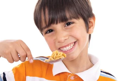 Smiling young boy with spoon of flakes, closeup Stock Photos