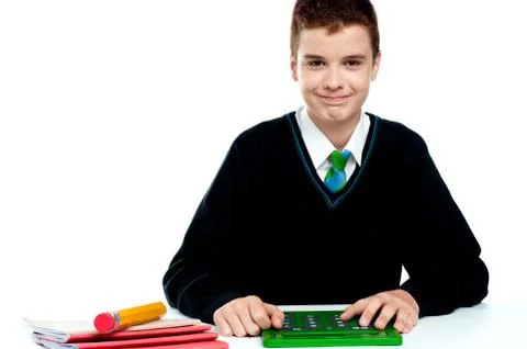 Smiling young boy using calculator Stock Photos
