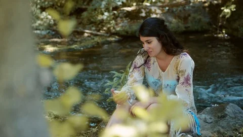 Smiling young brunette using smartphone near the river Stock Footage 83958429