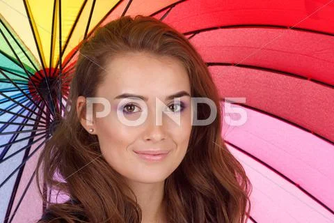Smiling young brunette woman in white blouse with umbrella Stock Photos