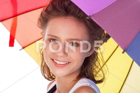 Smiling young brunette woman in white blouse with colour umbrella Stock Photos