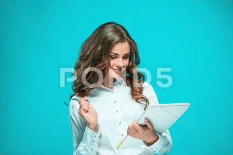The smiling young business woman with pen and tablet for notes on blue Stock Photos