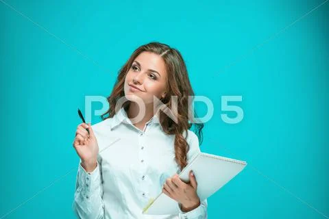 The smiling young business woman with pen and tablet for notes on blue Stock Photos