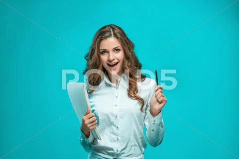 The smiling young business woman with pen and tablet for notes on blue Stock Photos