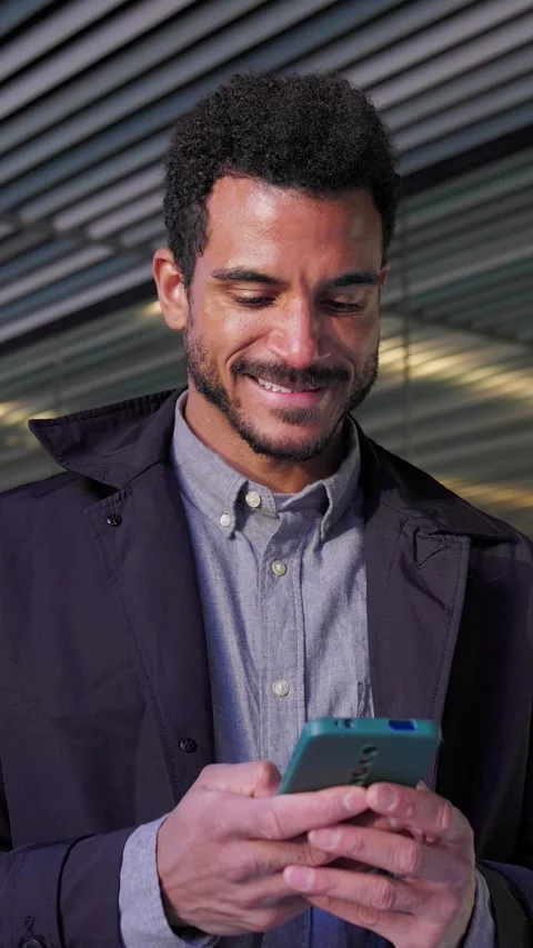 Smiling young businessman using smartphone app in modern city Stock Footage 345249482