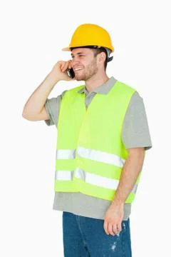 Smiling young construction worker on the cellphone Stock Photos
