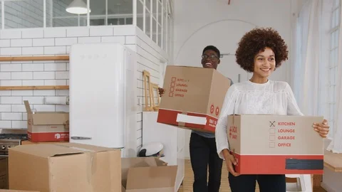 Smiling Young Couple Carrying Boxes Into New Home On Moving Day Vidéo 111936017
