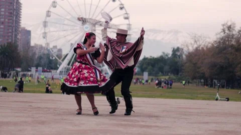 Smiling young couple dressed as Chilean huasos, joyfully dancing cueca Stock Footage 314416611