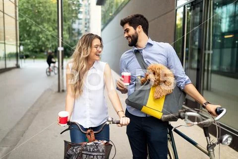 Smiling young couple going for a bike ride on a sunny day in the city Stock Photos