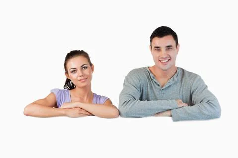 Smiling young couple looking over a wall Fotos Stock