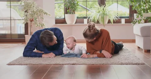 Smiling young couple lying together on rug on their living room floor at home Stock Footage 140189028