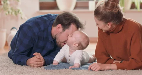 Smiling young couple lying together on rug on their living room floor at home 스톡 동영상 140189698