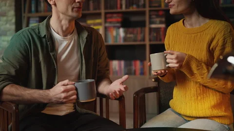 Smiling young couple talking over tea during romantic date in a library cafe Stock Footage 340266789