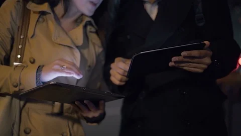 Smiling young couple using digital tablets outdoor at night Stock Footage 100890235