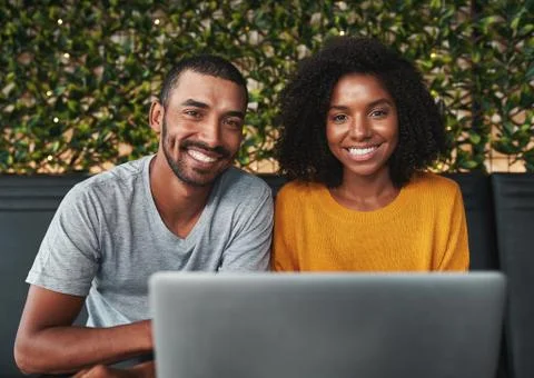 Smiling young couple using laptop Stock Photos