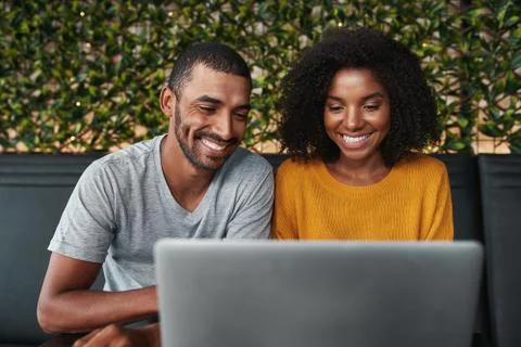 Smiling young couple using laptop Stock Photos