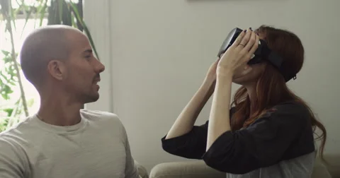 Smiling young couple using VR headset at home Vídeo Stock 63374651