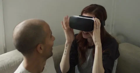 Smiling young couple using VR headset at home Vídeo Stock 63374671