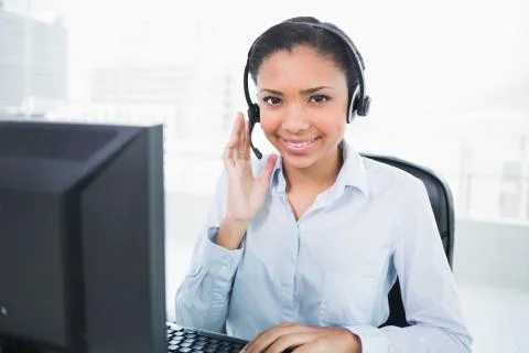 Smiling young dark haired operator answering a call Stock Photos