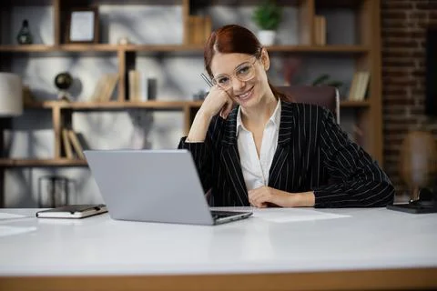 Smiling young female using internet banking service, searching information. 스톡 사진