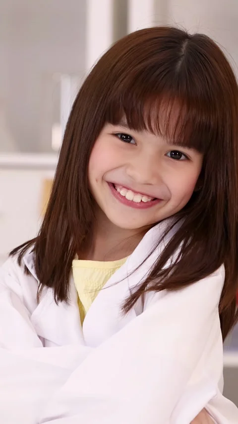 Smiling Young Girl in White Lab Coat in Science Classroom Stock Footage 344724892