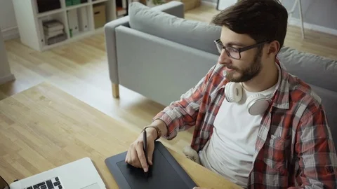 Smiling young graphic designer working in home office using graphics tablet Stock Footage 79802693