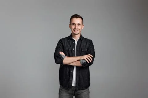 Smiling young guy posing with crossed arms Stockfoto's