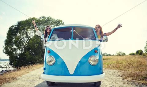 Smiling young hippie women driving minivan car Stock Photos