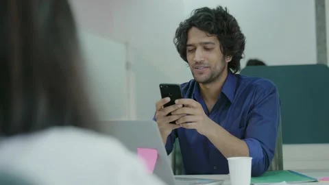 Smiling young India man using smart phone surfing social media. Видео 168218620